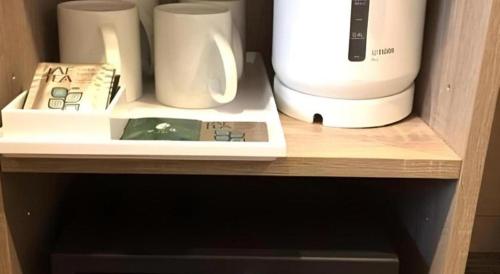 a shelf with a coffee maker and cups on it at Hotel IL FIORE Kasai in Tokyo