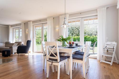a dining room and living room with a table and chairs at Reethaus MeerFerien direkt am Wasser in Mellnitz