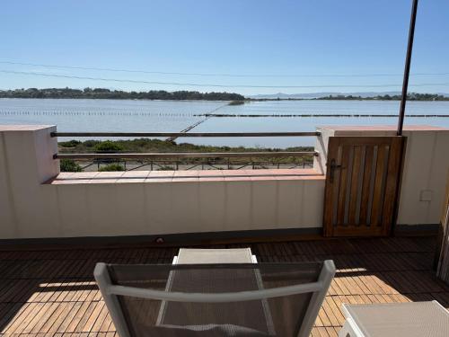 a balcony with a table and a view of the water at LE SALINE: beautiful apartment with terrace and splendid view in Carloforte