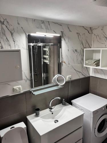 un bagno con lavandino, WC e specchio di Ocean view a Puerto Rico de Gran Canaria