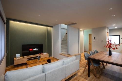 a living room with a couch and a television at 福八 Neighbors Osaka UMEDA in Osaka