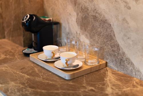 a tray with cups and glasses on a coffee maker at The Ozone Residences Bangtao in Phuket