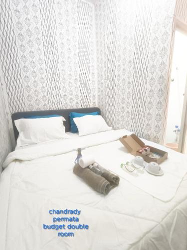a bedroom with two beds with a white comforter at Chandrady Permata Guest House 2 in Jakarta