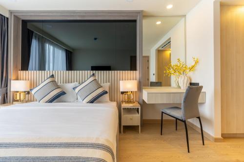 a hotel room with a bed and a desk at The Ozone Residences Bangtao in Phuket