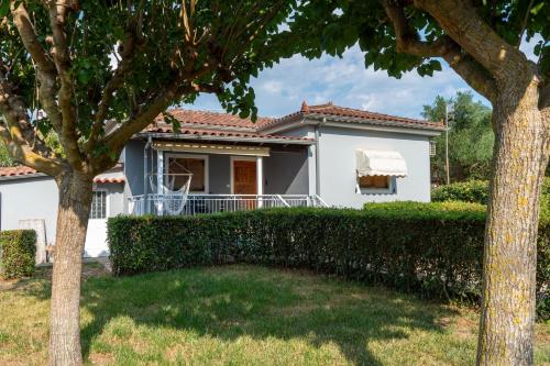 a white house with trees in front of it at Olivilla Garden Retreat - A Peaceful Escape in Éva
