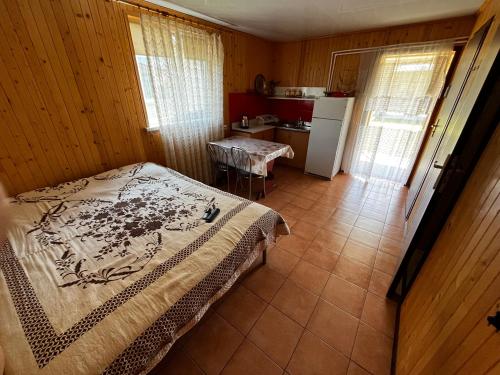 a small bedroom with a bed and a kitchen at Будиночки rio de pulmo in Pulʼmo