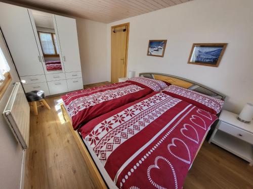 a bedroom with a bed with a red and white comforter at Uf em Schloss in Biel