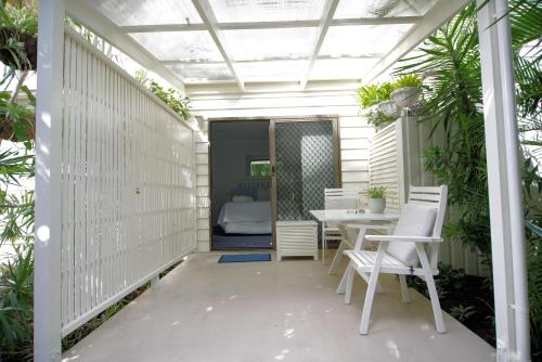 a patio with a table and chairs and a bedroom at Debbie's Place in Rainbow Beach