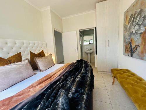 a bedroom with a large bed and a sink at 2 On Lismore Guesthouse in Tokai