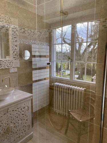 a bathroom with a shower and a sink and a window at Les Carillons du Bois de l'Orme in Les Pechs-du-Vers