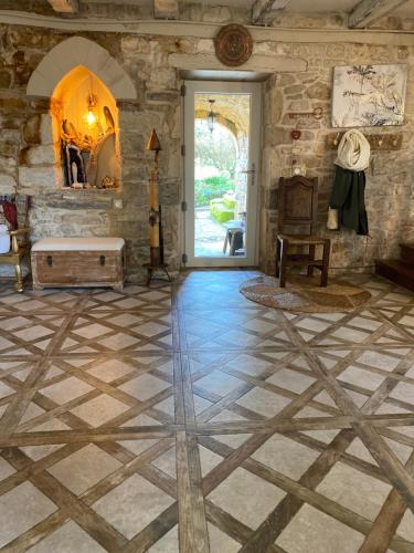 a living room with a stone wall and a door at Les Carillons du Bois de l'Orme in Les Pechs-du-Vers