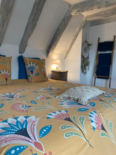 a bedroom with a bed with a colorful bedspread at Les Carillons du Bois de l'Orme in Les Pechs-du-Vers