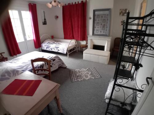a living room with two beds and a fireplace at Pluie de roses in Royan