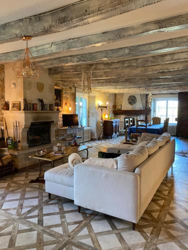 a living room with a couch and a fireplace at Les Carillons du Bois de l'Orme in Les Pechs-du-Vers