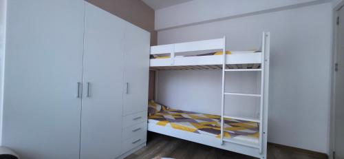 a white bedroom with a bunk bed and white cabinets at Divine place Pomorie in Pomorie