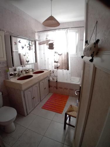 a bathroom with a sink and a tub and a toilet at Pluie de roses in Royan