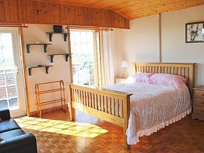 ein Schlafzimmer mit einem Bett und einer Couch in einem Zimmer in der Unterkunft Mariners Lodge in Felixstowe