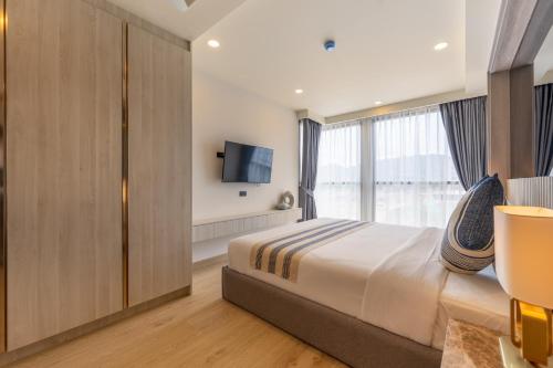 a bedroom with a large bed and a window at The Ozone Residences Bangtao in Phuket