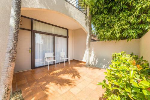 an empty patio with two white chairs in a house at Wyndham Palmas Beach and Golf Boutique Resort in Humacao