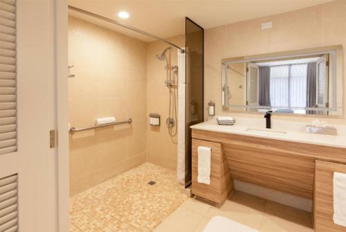 a bathroom with a shower and a sink and a mirror at Wyndham Palmas Beach and Golf Boutique Resort in Humacao