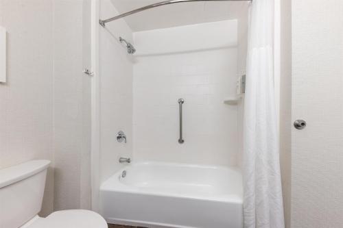 a white bathroom with a shower and a toilet at Hampton Inn Phoenix Midtown Downtown Area in Phoenix