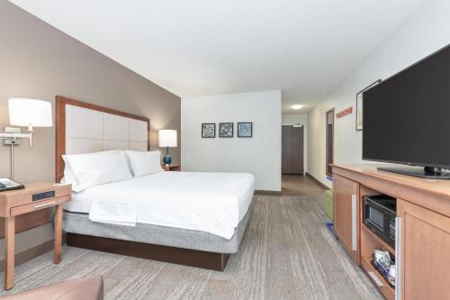 a hotel room with a bed and a flat screen tv at Hampton Inn Phoenix Midtown Downtown Area in Phoenix