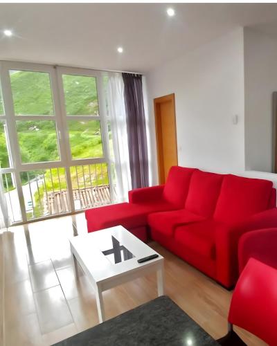 a living room with a red couch and a table at El Mirador in Tudanca