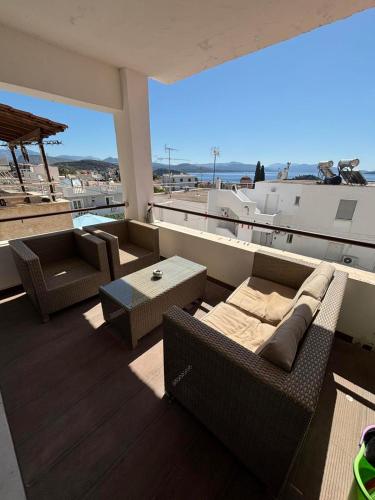 a balcony with furniture and a view of the ocean at Evelina's House in Tolo