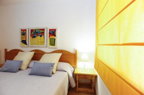 a bedroom with a bed with two blue pillows at FLORA Apartment in Cambrils