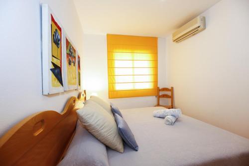 a bedroom with a bed with a wooden headboard and a window at FLORA Apartment in Cambrils