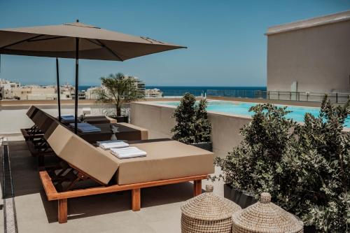 a patio with a table and an umbrella at 1926 Les Bains Private Spa Suites in Sliema