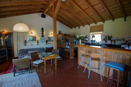 a living room with a counter and a bar with chairs at Casa Vicentina in Odeceixe
