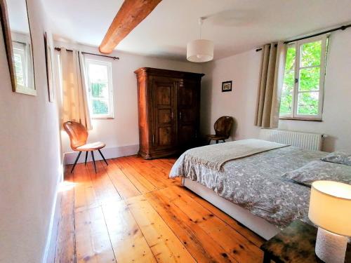 a bedroom with a bed and two chairs in it at Maison Kobold XVIè siècle in Wissembourg