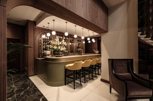a bar with a row of stools in a room at 1926 Les Bains Private Spa Suites in Sliema