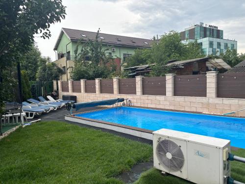 une piscine avec ventilateur et chaises dans une cour dans l'établissement Bob Residence & pool, à Cluj-Napoca