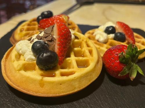 a waffle with strawberries and blueberries on a plate at Penzión Liezky in Mýto pod Ďumbierom