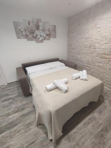 a bedroom with a large bed with towels on it at Il canto del mare in Giovinazzo