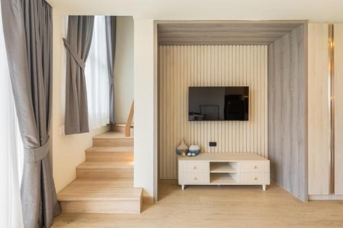 a living room with a white cabinet and a staircase at The Ozone Residences Bangtao in Phuket
