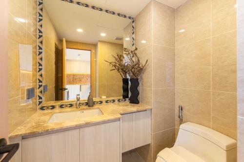 a bathroom with a toilet and a sink and a mirror at The Ozone Residences Bangtao in Phuket