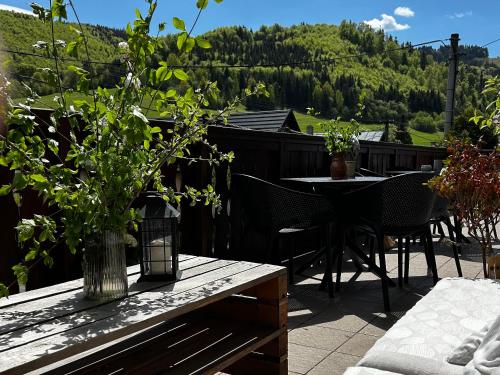 a patio with a table and chairs with a view of a mountain at Penzión Liezky in Mýto pod Ďumbierom