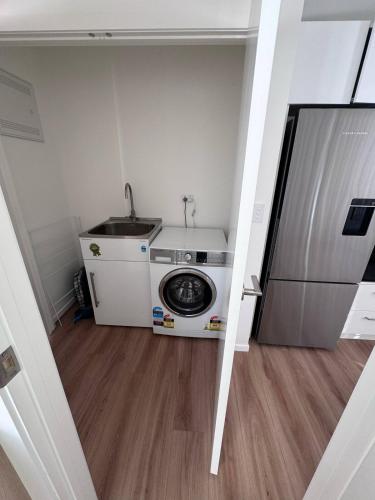a laundry room with a washing machine and a sink at One bedroom apartment in Queenstown Airport