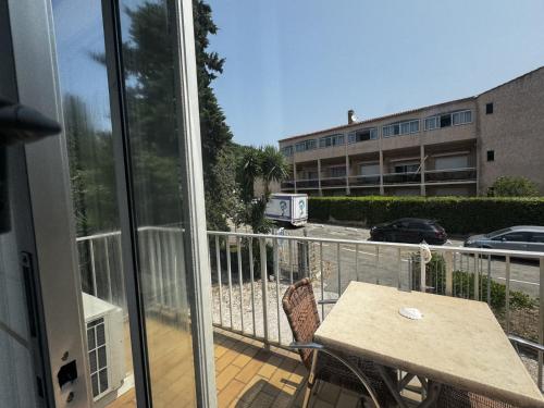 a balcony with a table and a view of a building at Hotel Le Golfe Bleu in Cavalaire-sur-Mer