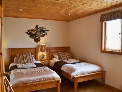 a bedroom with two beds and a ceiling with a window at The Shank in Fritton Norfolk