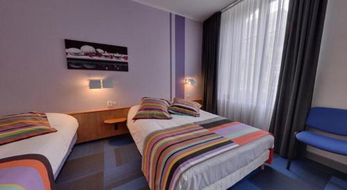 Habitación de hotel con 2 camas y ventana en Logis Hotel de Paris, en Saint-Avold
