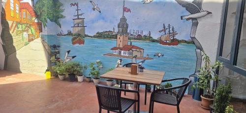 a table and chairs in front of a wall with a mural at Grand Bedir in Istanbul