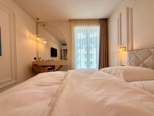 a bedroom with a large white bed and a desk at FeWo No 408 Lebada Lake in Pantelimon