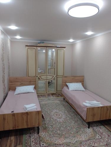 a bedroom with two beds and a mirror at Arzu Guesthouse in Ak-Say