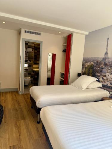 two beds in a room with a view of the eiffel tower at Stella Etoile in Paris