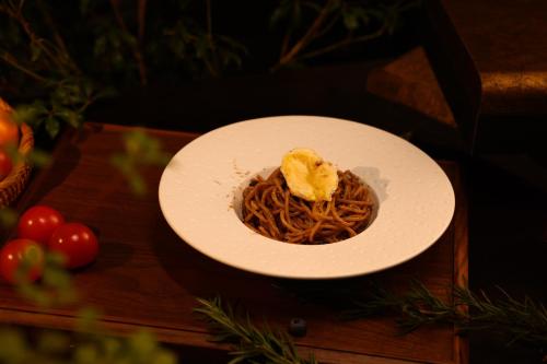 a plate of spaghetti on a wooden table at Lijiang Jijian Xiangwang SOOOAN Luxury Resort Hotel in Lijiang