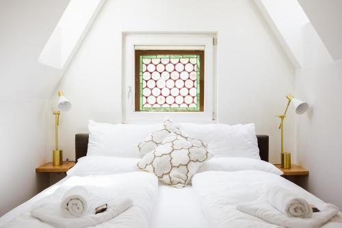 a bedroom with a bed with white sheets and a window at GH Luxury Apartments Graz, Glockenspielplatz in Graz